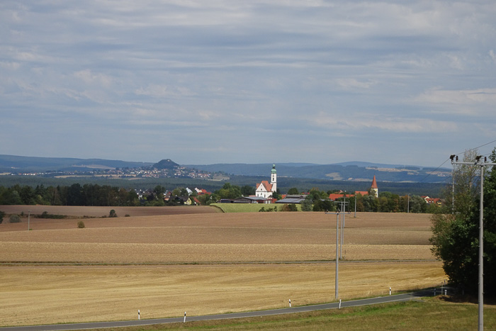 Neunkirchen mit seinen zwei Kirchen, links dahinter der Parkstein mit seinem einen Vulkankegel.
